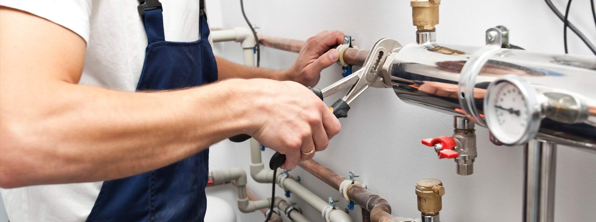 Technician servicing plumbing and heating equipment.